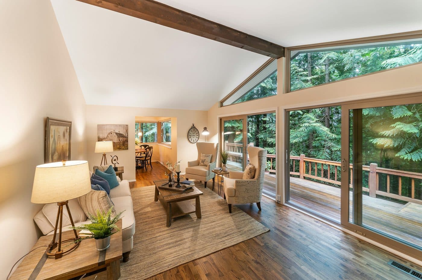Home addition with vaulted ceiling, exposed beam, and deck access by Summit Ridge Renovations