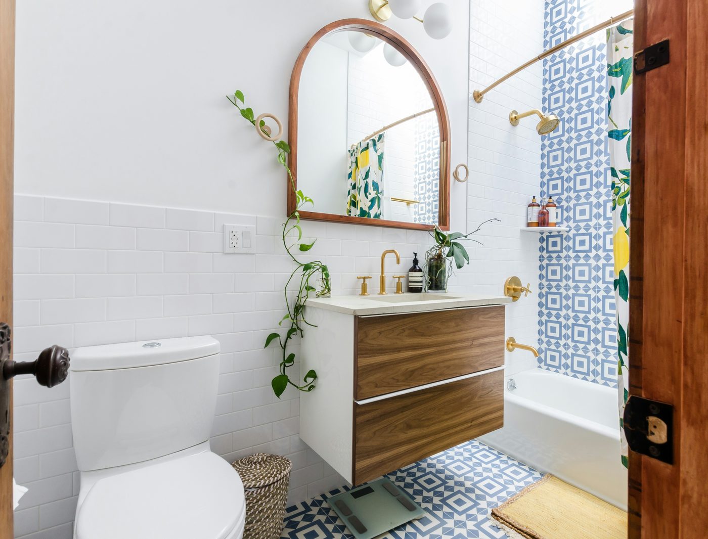 Bathroom remodel with patterned tile, walnut vanity, and gold fixtures